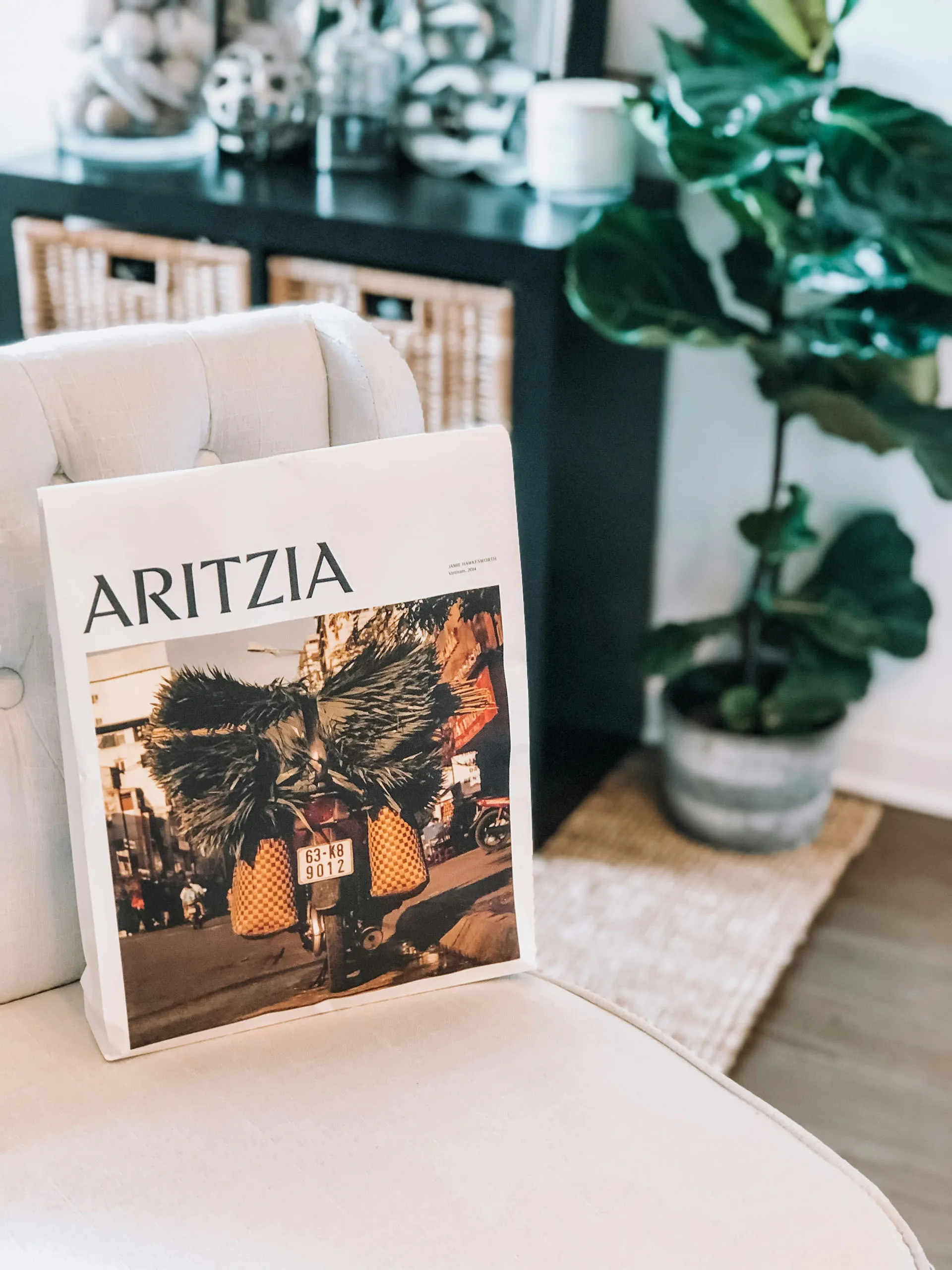  Aritzia shopping bag on a white leather chair in a living room