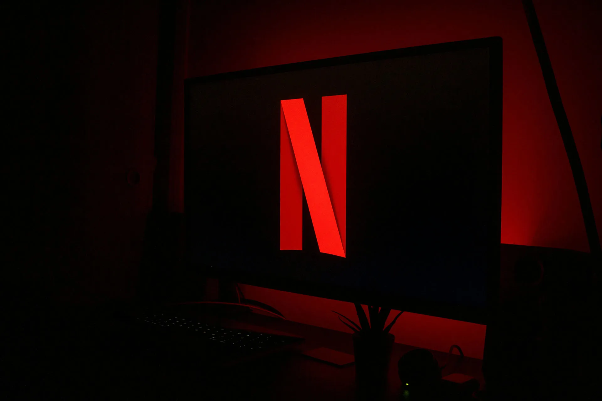  The Netflix logo on a TV in a dark room with red backlight