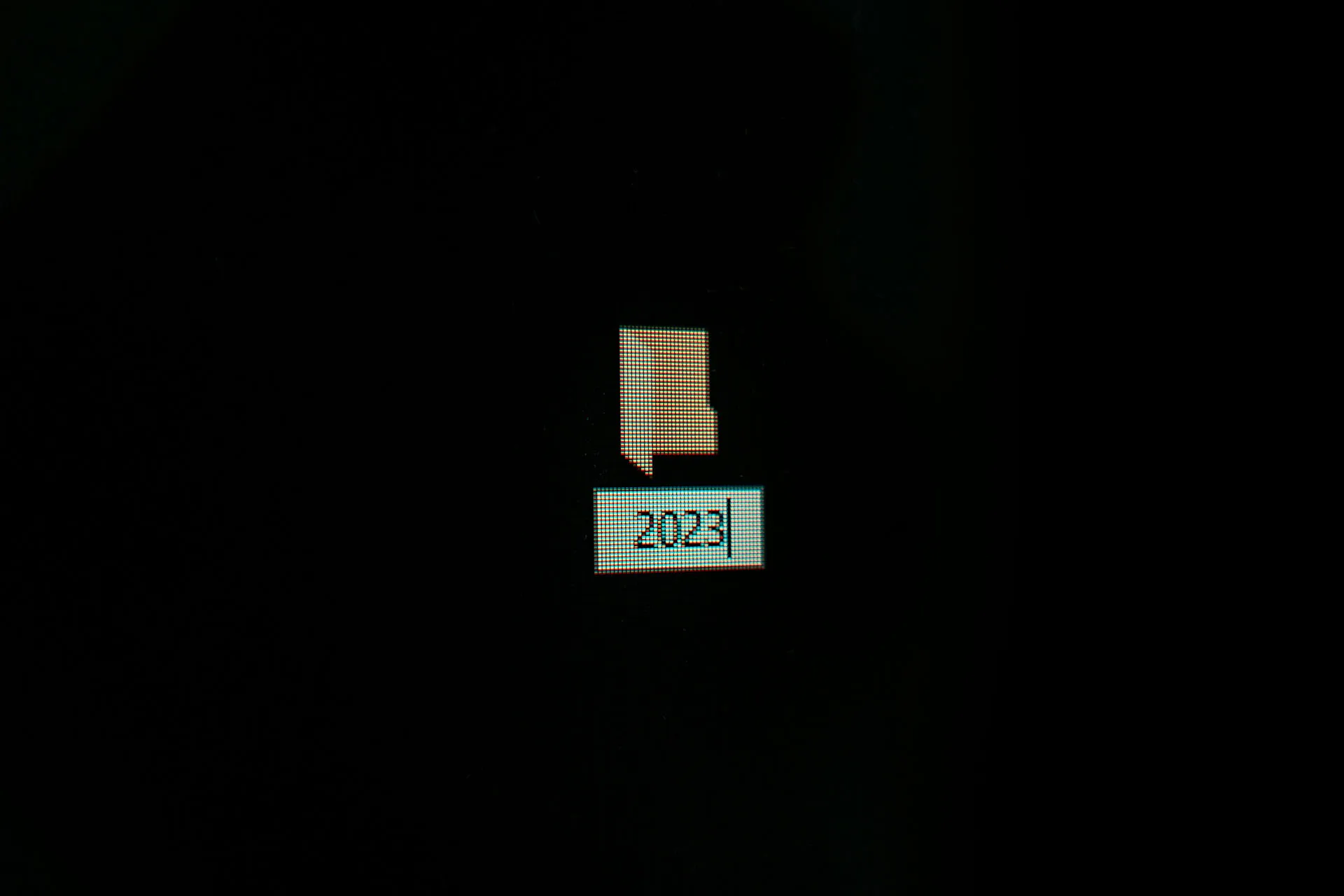 A computer screen displaying a small folder icon and the year 2023 on a dark background.