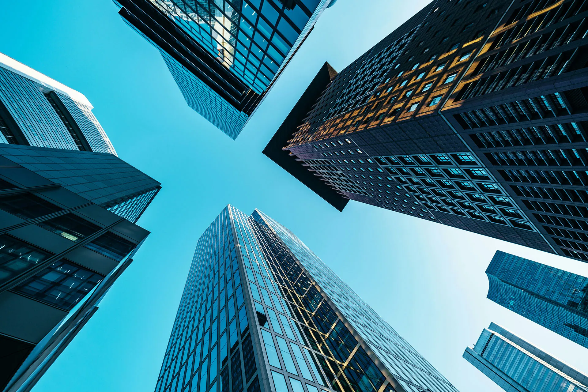  Modern glass office buildings and skyscrapters viewed from below against a clear blue sky