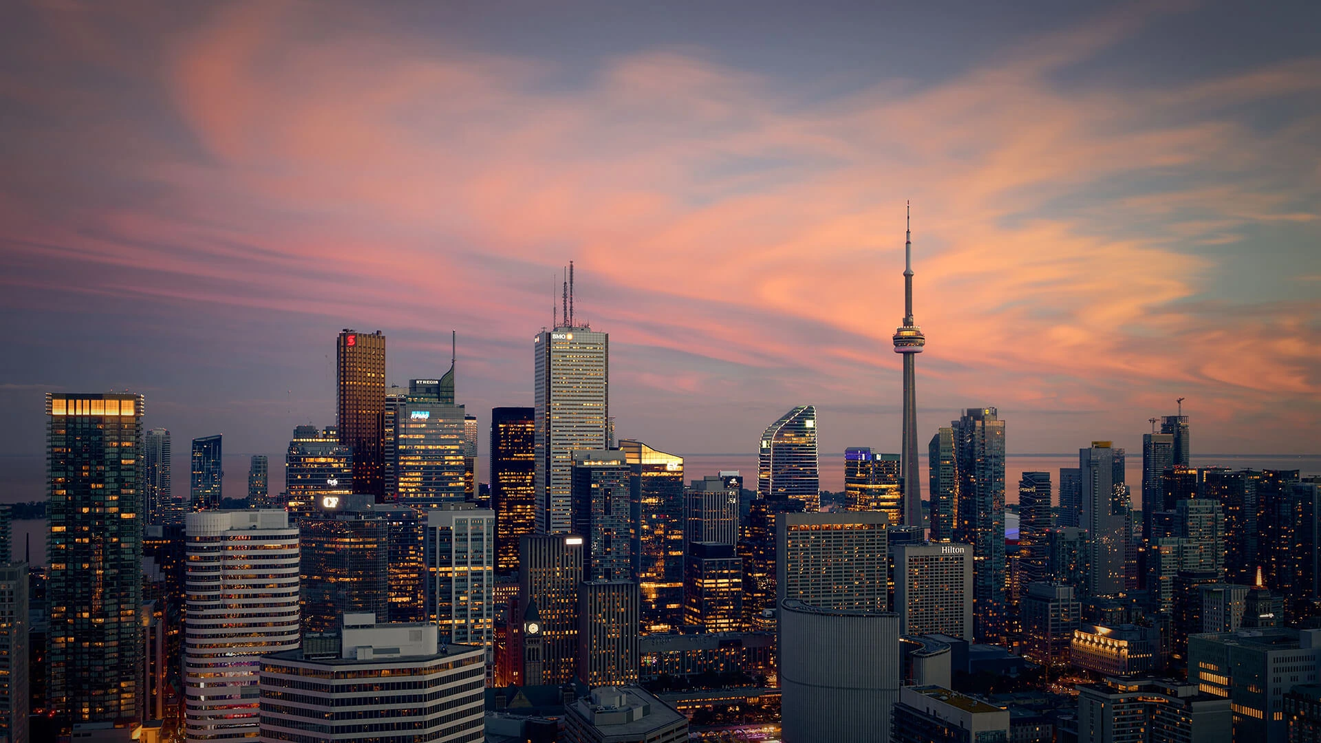 Arial perspective of the Toronto Financial District skyscrapers lit up at dusk